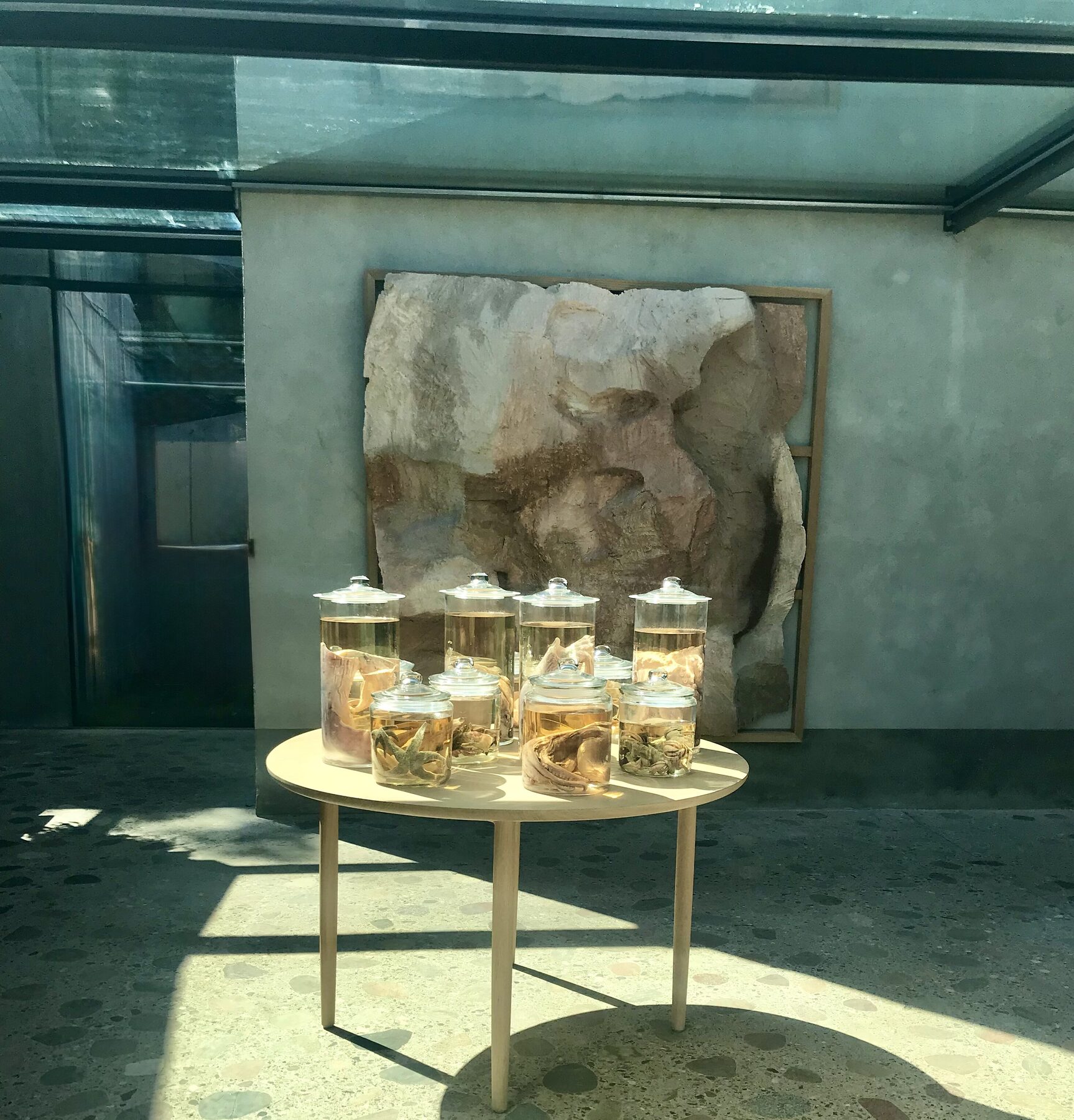 A sunlit, calm interior with glass vessels on a round table